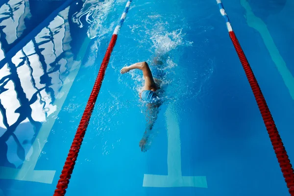 Foto de hombre deportivo nadando con estilo de rastreo en la piscina cubierta —  Fotos de Stock