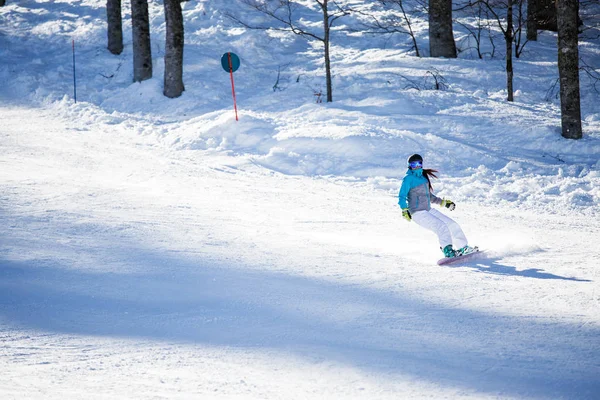 Foto de menina de esportes usando capacete e máscara de snowboard na encosta nevada — Fotografia de Stock