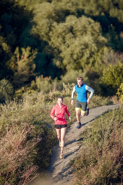 Image of young sports girl and man jogging among trees — Stock Photo, Image