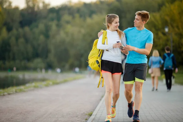 Immagine di abbracciare donne e uomini sportivi che vanno al parco — Foto Stock