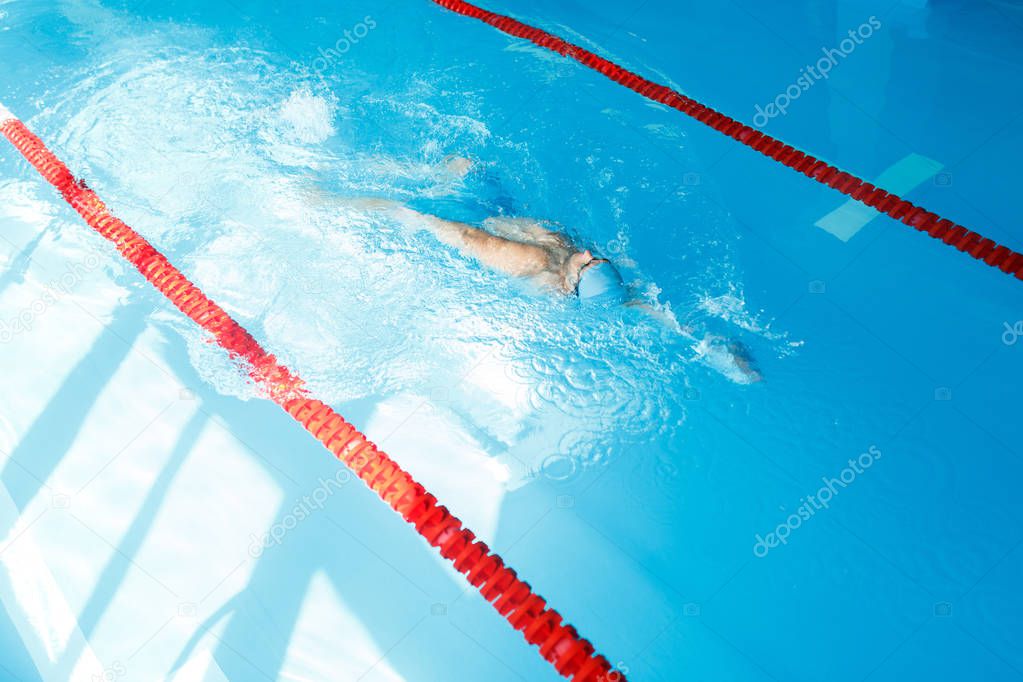 Image on top of man swimming on back in swimming pool