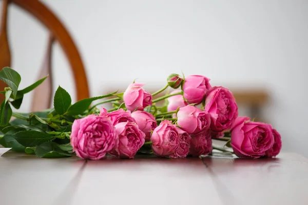 Foto de peonías rosadas sobre mesa de madera blanca — Foto de Stock