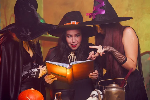 Foto de tres brujas con libro en las manos — Foto de Stock