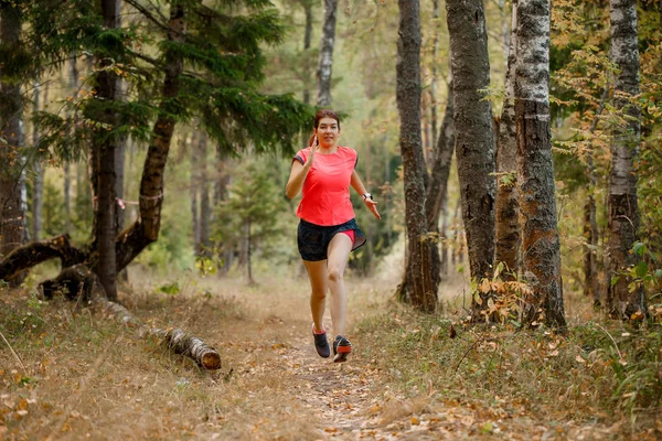 Изображение со спины спортивной женщины, бегущей по лесу — стоковое фото