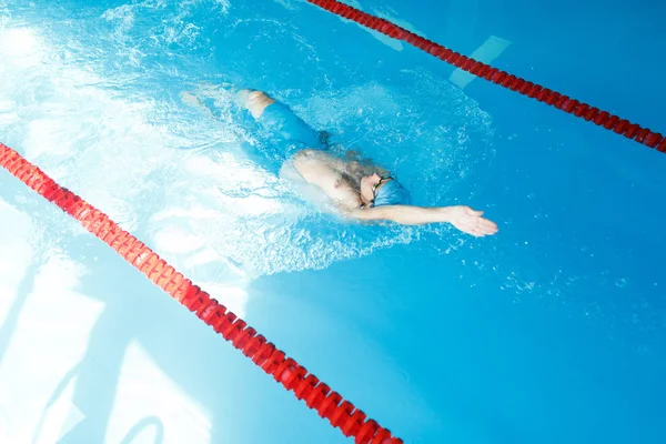 Bild oben auf Sportler Mann schwimmt auf Rücken in Schwimmbad — Stockfoto