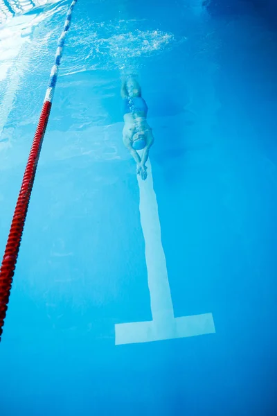 Foto oben auf Sportler Mann schwimmt auf der Rückseite des Hallenbades — Stockfoto