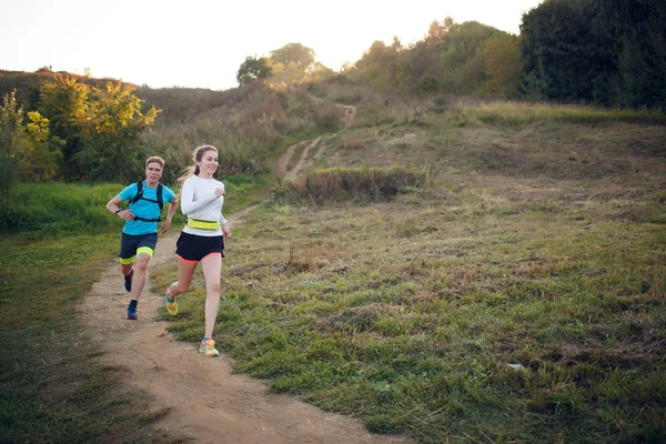 Photo of athlete woman and man running through park — Stock Photo, Image