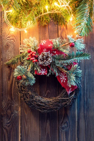 Χριστούγεννα στεφάνι σε ένα ρουστίκ ξύλινη πόρτα. — Φωτογραφία Αρχείου