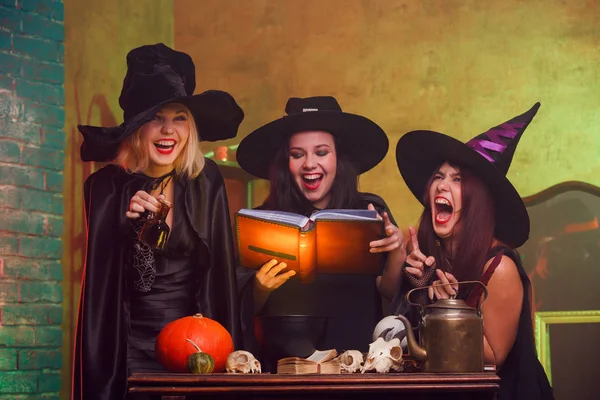 Foto de tres brujas con libro de predicciones en las manos — Foto de Stock