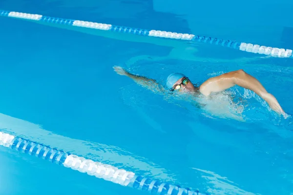 Foto de hombre deportivo con gorra azul nadando en la piscina — Foto de Stock