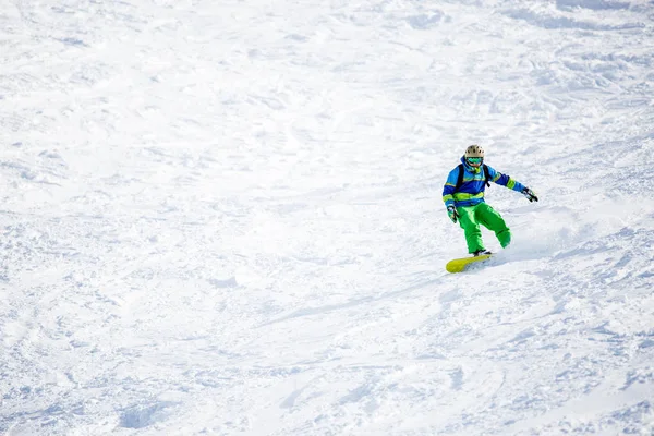 Foto de un deportista haciendo snowboard en la ladera nevada —  Fotos de Stock