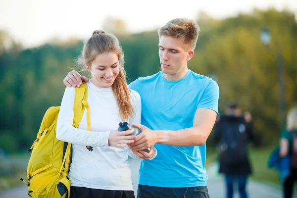 Foto di coppia giovani sportivi che guardano l'orologio nel parco — Foto Stock