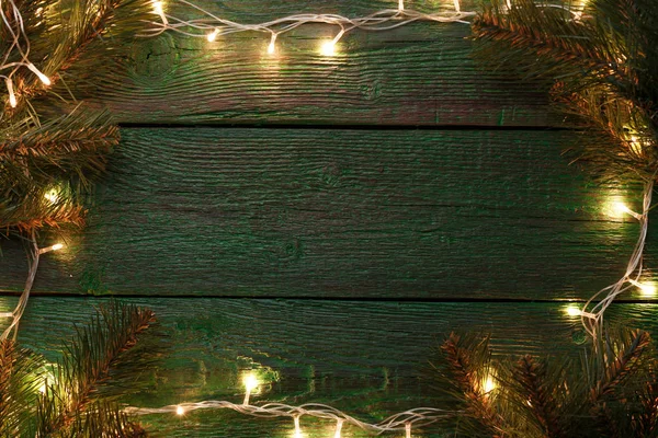 Photo of New Years background with burning garland around perimeter, branches of spruce. — Stock Photo, Image