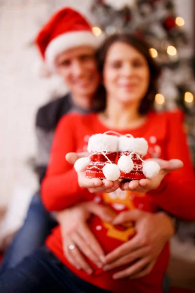 Foto de casal feliz com botas no fundo de decorações de Natal — Fotografia de Stock