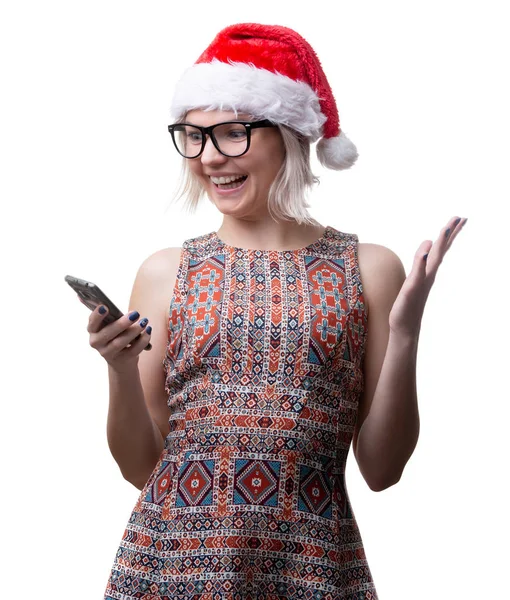 Фото блондинки в окулярах і шапка Сантаса з телефоном в руці на порожньому просторі — стокове фото