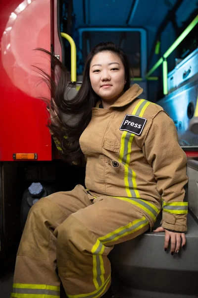 Изображение женщины-пожарного на фоне пожарной машины — стоковое фото