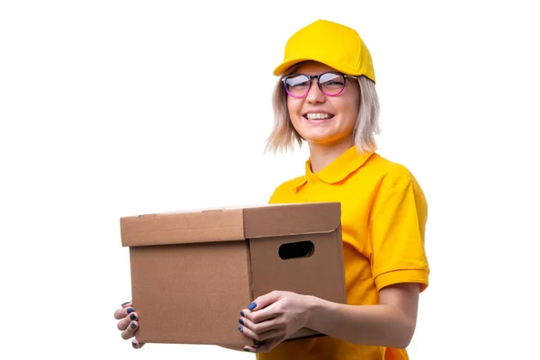 Image of courier woman with glasses and yellow T-shirt with cardboard box in her hands — Stock Photo, Image