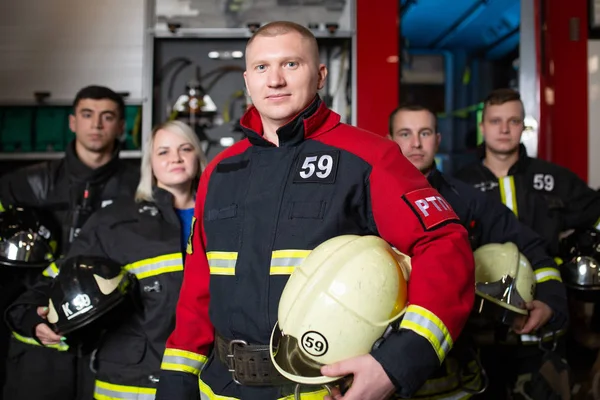 Foto av fyra brandmän och kvinna på bakgrund av brandbil — Stockfoto