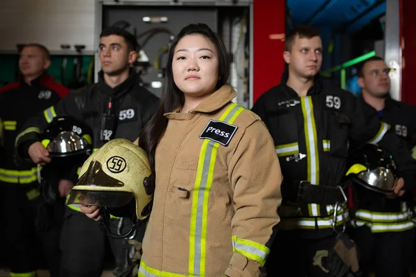 Retrato de cuatro bomberos masculinos y femeninos en el fondo del camión de bomberos —  Fotos de Stock