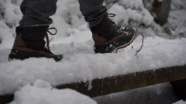 Slomo clip di primo piano femminile stivali invernali caldi a piedi nella neve profonda . — Video Stock