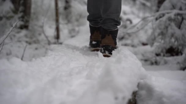 Slomo klipp av närbild kvinnliga varm vinter stövlar promenader i djup snö. — Stockvideo