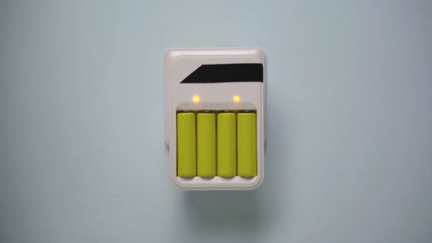 Carregador de parede de bateria com baterias na tomada de parede — Vídeo de Stock