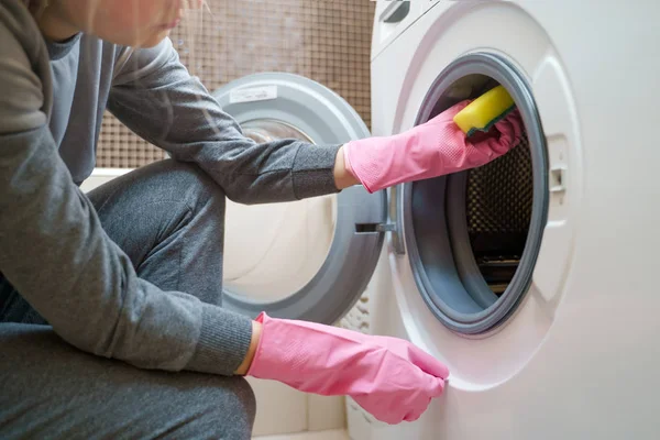 Photo of woman s hand in pink rubber glove washing washing machine — Stock Photo, Image