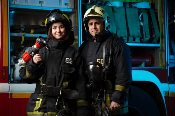 Foto de bombero y mujer cerca de camión de bomberos — Foto de Stock
