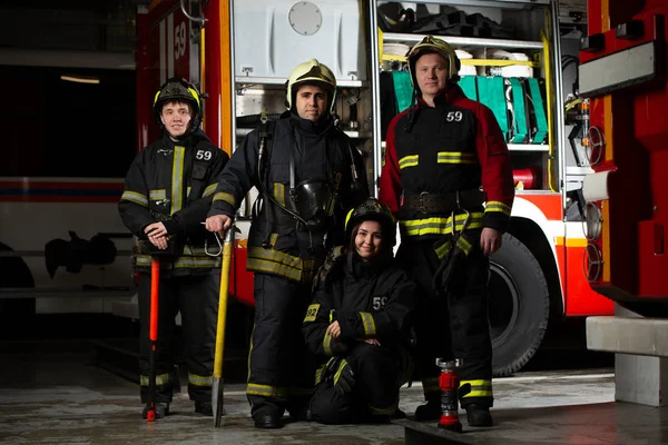 Foto de tres bomberos cerca de camión de bomberos — Foto de Stock