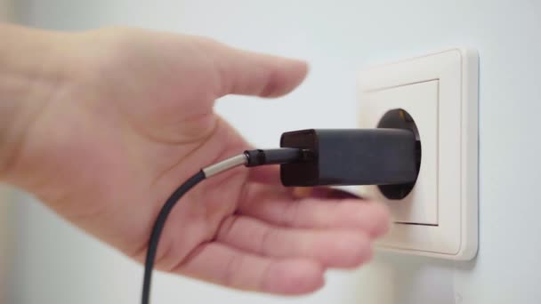 Fechar-se de uma mão desligando carregador de parede USB . — Vídeo de Stock