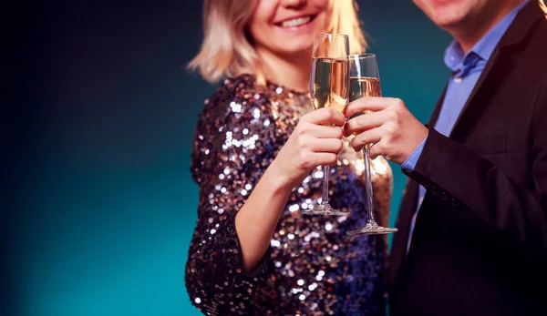 화려한 드레스와 파란색 배경에 샴페인 와인 안경 남자 여자의 사진 — 스톡 사진