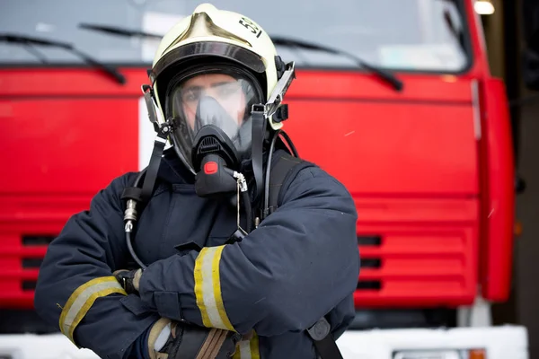 Picture of man fireman in gas mask near fire truck