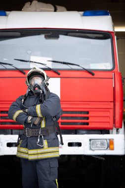 Adam itfaiyeci itfaiye arabası yakınındaki gaz maskeli resmini