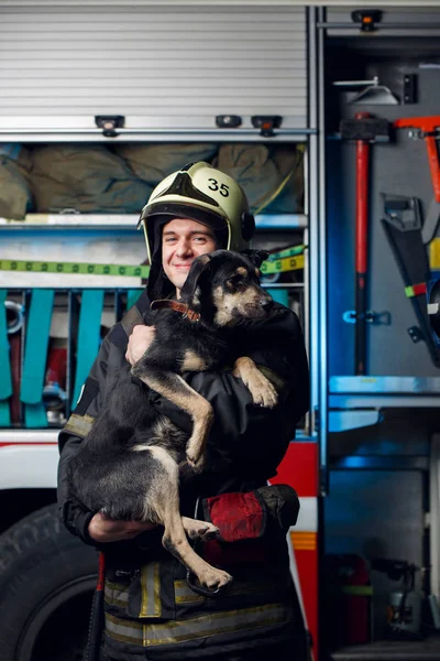 Foto Bombero Joven Casco Con Perro Fondo Del Camión Bomberos — Foto de Stock