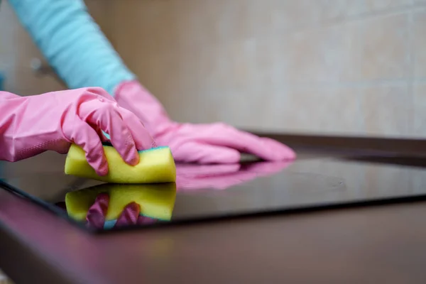 Foto de mãos femininas em luvas de borracha rosa lavar fogão — Fotografia de Stock