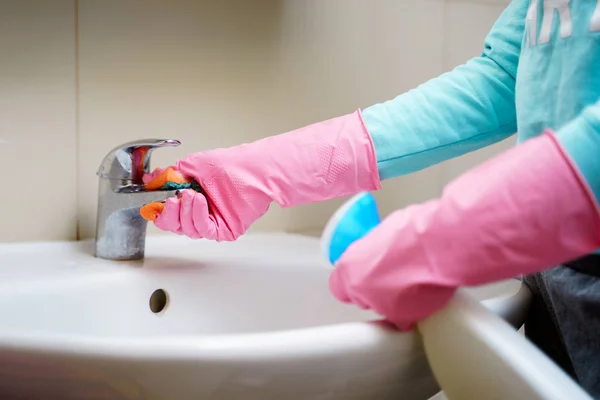 Foto de mãos de mulher em luvas de borracha lavatório no banho — Fotografia de Stock