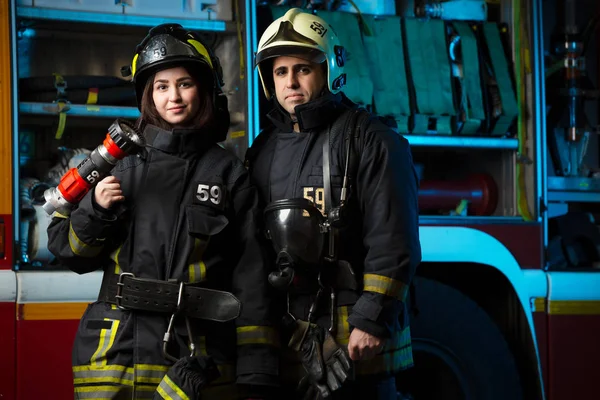 Hasič a žena poblíž hasičský vůz — Stock fotografie