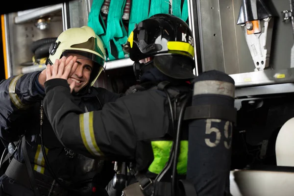 Image of two firemen men making handshake near fire truck — Stock fotografie