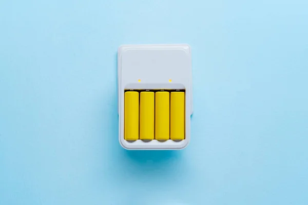 Photo of charger with yellow batteries — Stock Photo, Image