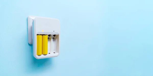 2 つの黄色の電池と充電器の写真 — ストック写真