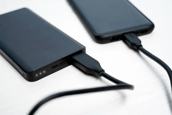 Photo of black powerbank with smartphone — Stock Photo, Image