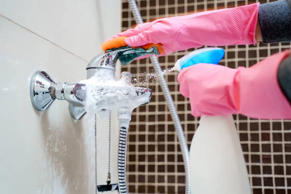 Image of hands in pink rubber gloves washing bathtub mixer — Stock Photo, Image