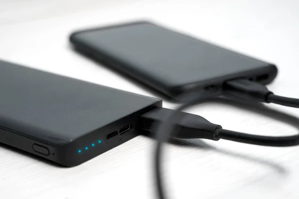 Image of black powerbank with smartphone — Stock Photo, Image