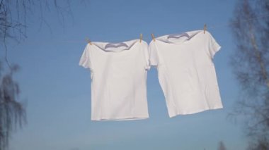 Clothesline üzerinde asılı beyaz t-shirt.