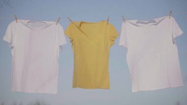 Mavi gökyüzü karşı clothesline asılı T-shirt