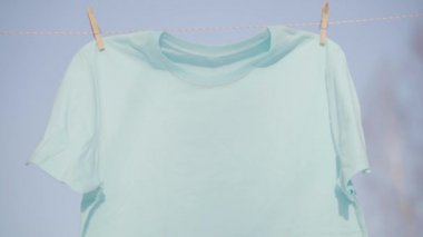 Mavi gökyüzü karşı clothesline asılı T-shirt
