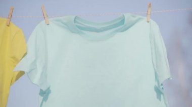 Mavi gökyüzü karşı clothesline asılı T-shirt