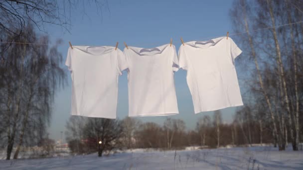 Футболки, висящие на веревке под голубым небом — стоковое видео