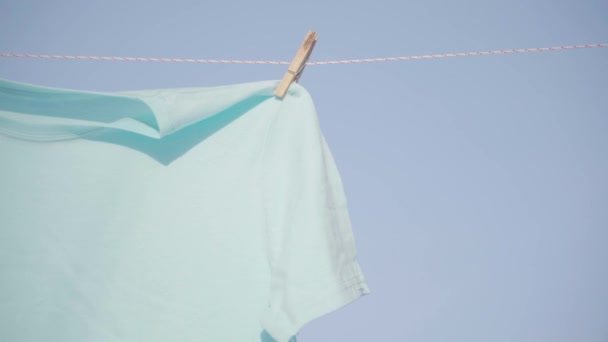 Ο άνθρωπος βάλει καρφίτσες κλιπ σε ξήρανση κρεμώντας άπλωμα ρούχων t-shirt το χειμώνα — Αρχείο Βίντεο