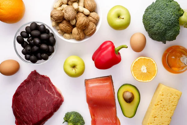 Foto op de top van stukje vlees, vis, kaas, eieren, groenten, fruit, olijven, walnoten — Stockfoto